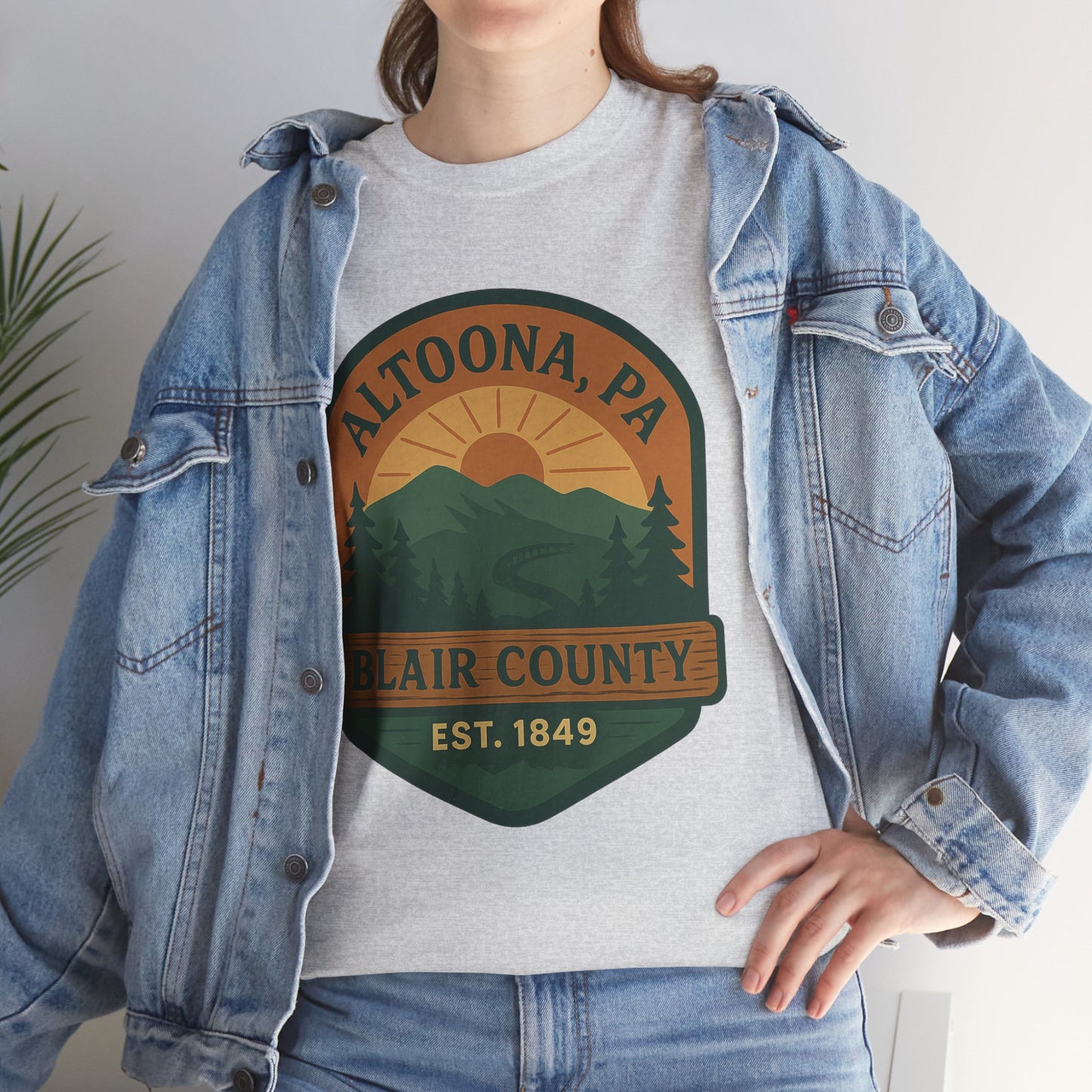 Grey Altoona adventure t-shirt featuring Blair County mountains and sunset design worn with denim jacket