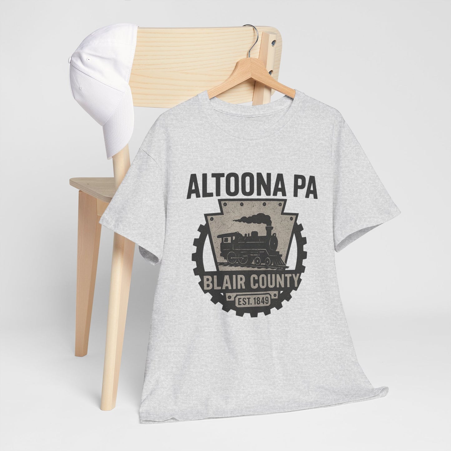 Gray Printify Altoona PA t-shirt featuring Blair County train graphic hanging on wooden chair