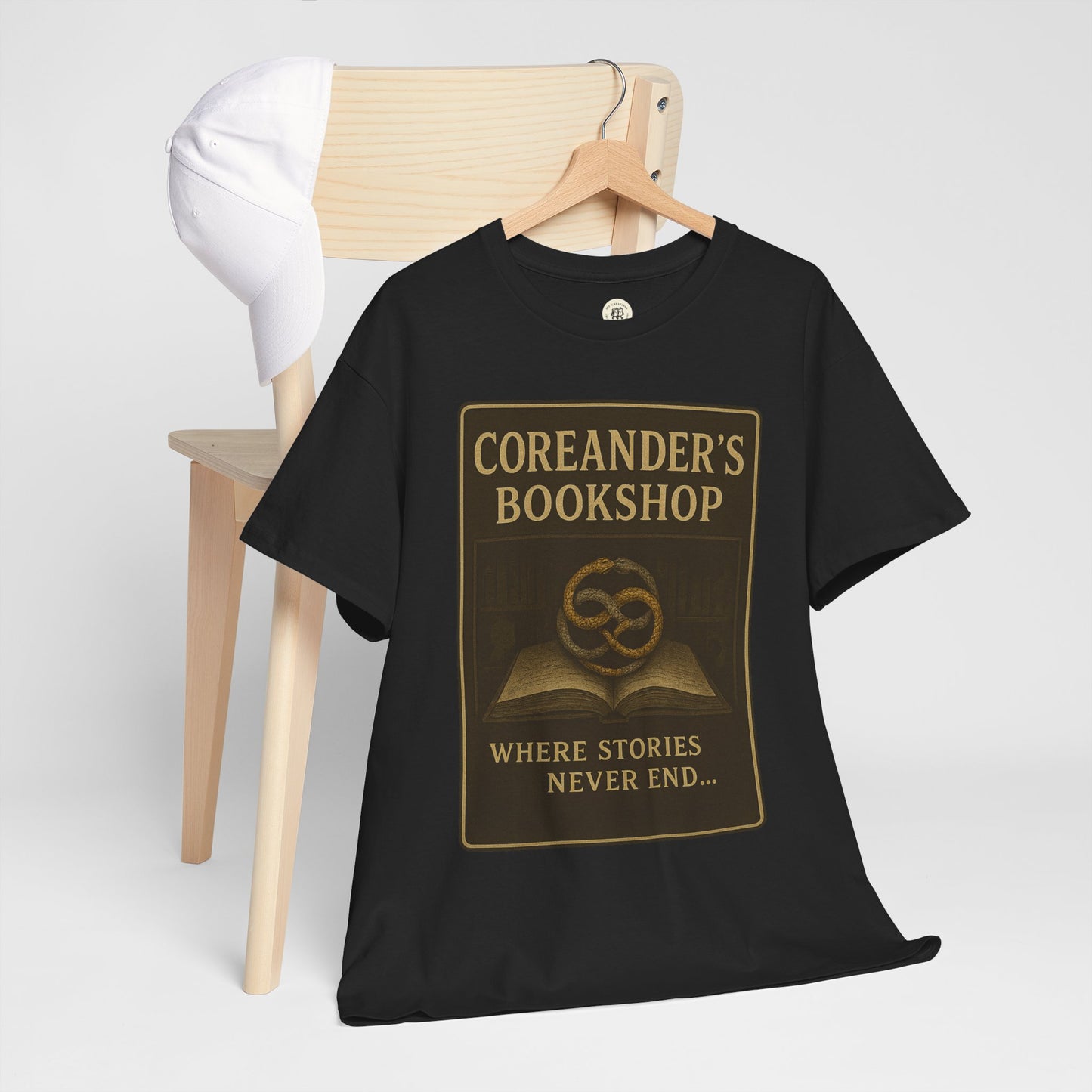 Black Neverending Story t-shirt with Coreanders Bookshop design and gold lettering on a wooden hanger