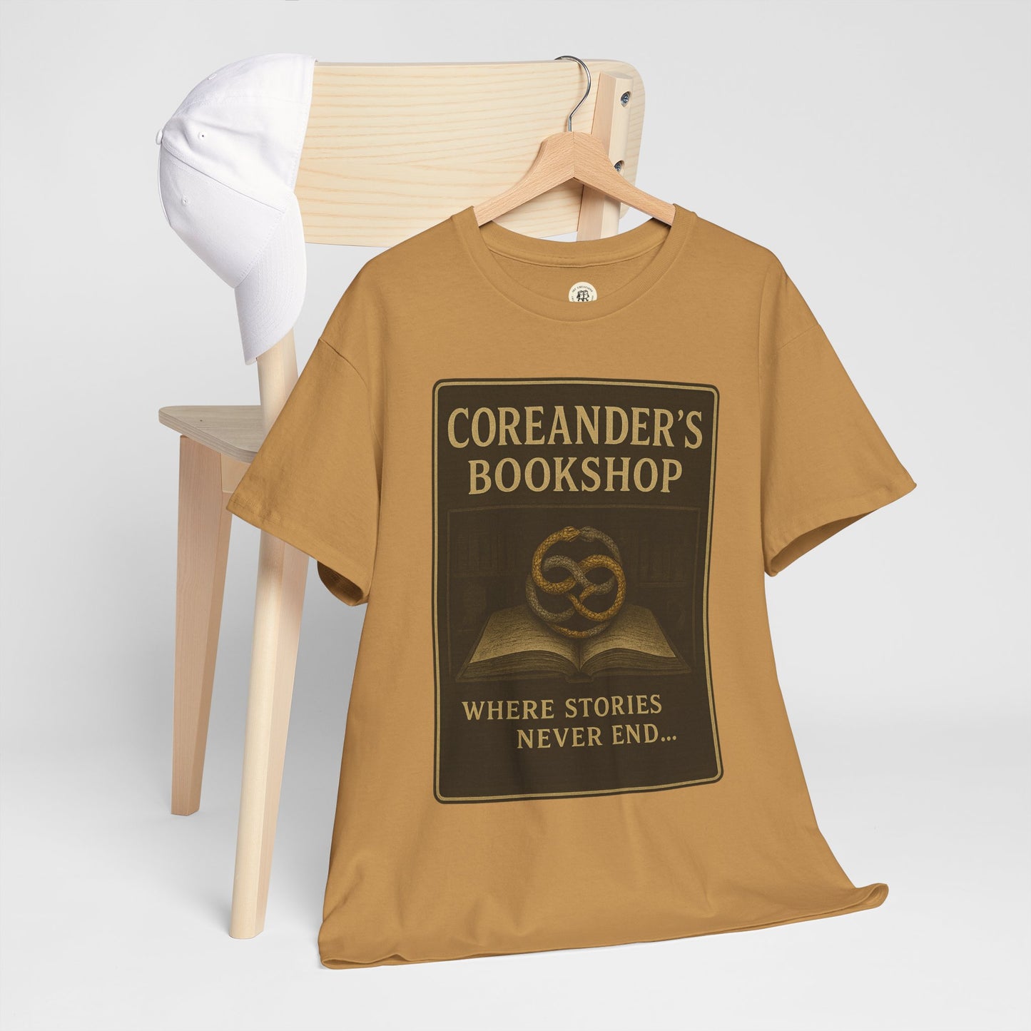 Printify Neverending Story t-shirt in brown with Coreander's Bookshop design hanging on wooden chair