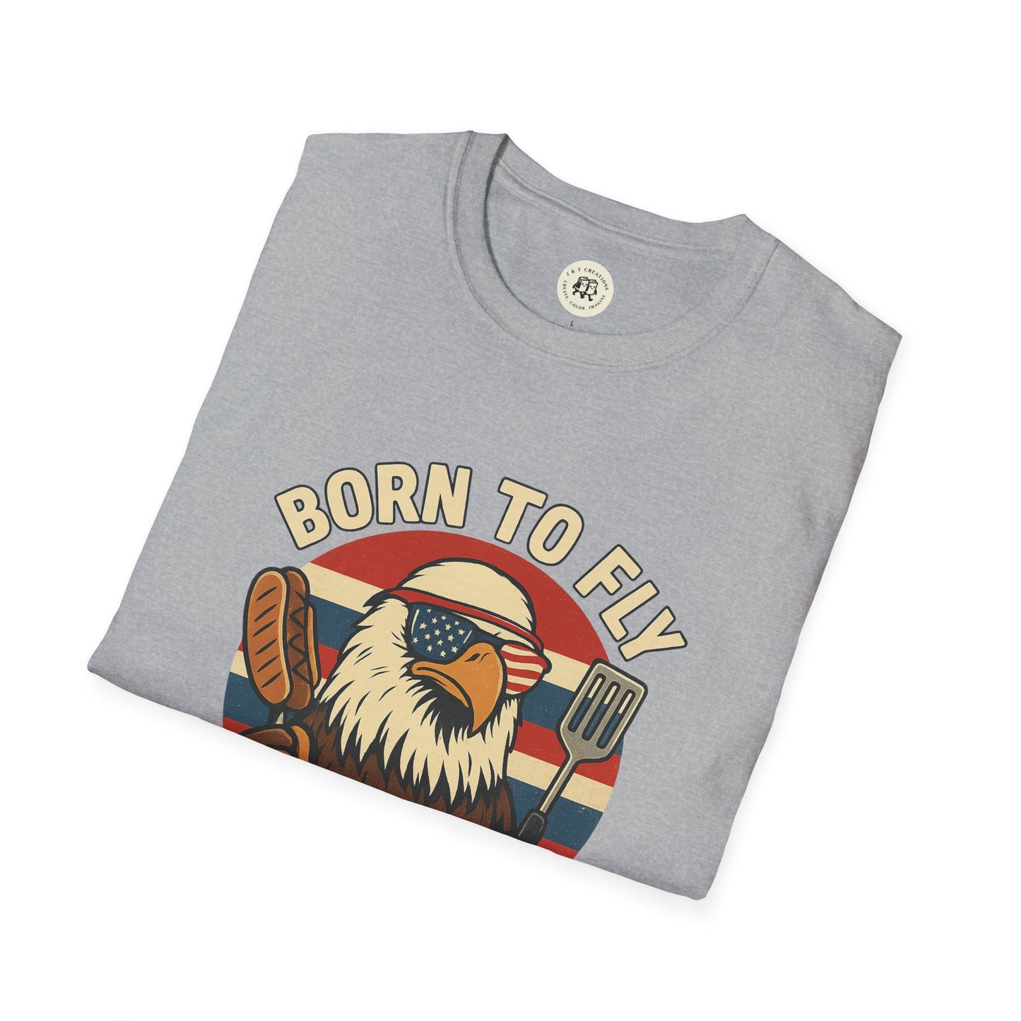 Folded gray Printify T-shirt with funny summer BBQ shirts design featuring eagle with sunglasses and grilling tools