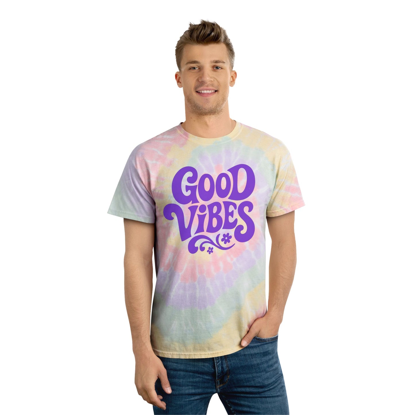 Smiling man wearing a rainbow tie-dye t-shirt with purple Good Vibes text and casual jeans
