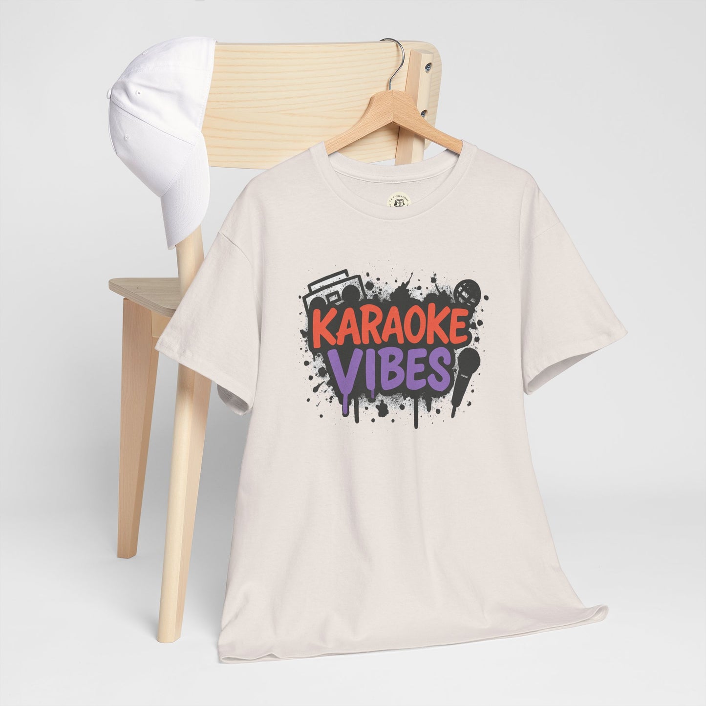 White Printify karaoke t-shirt for parties with colorful karaoke vibes graphic hanging on wooden chair