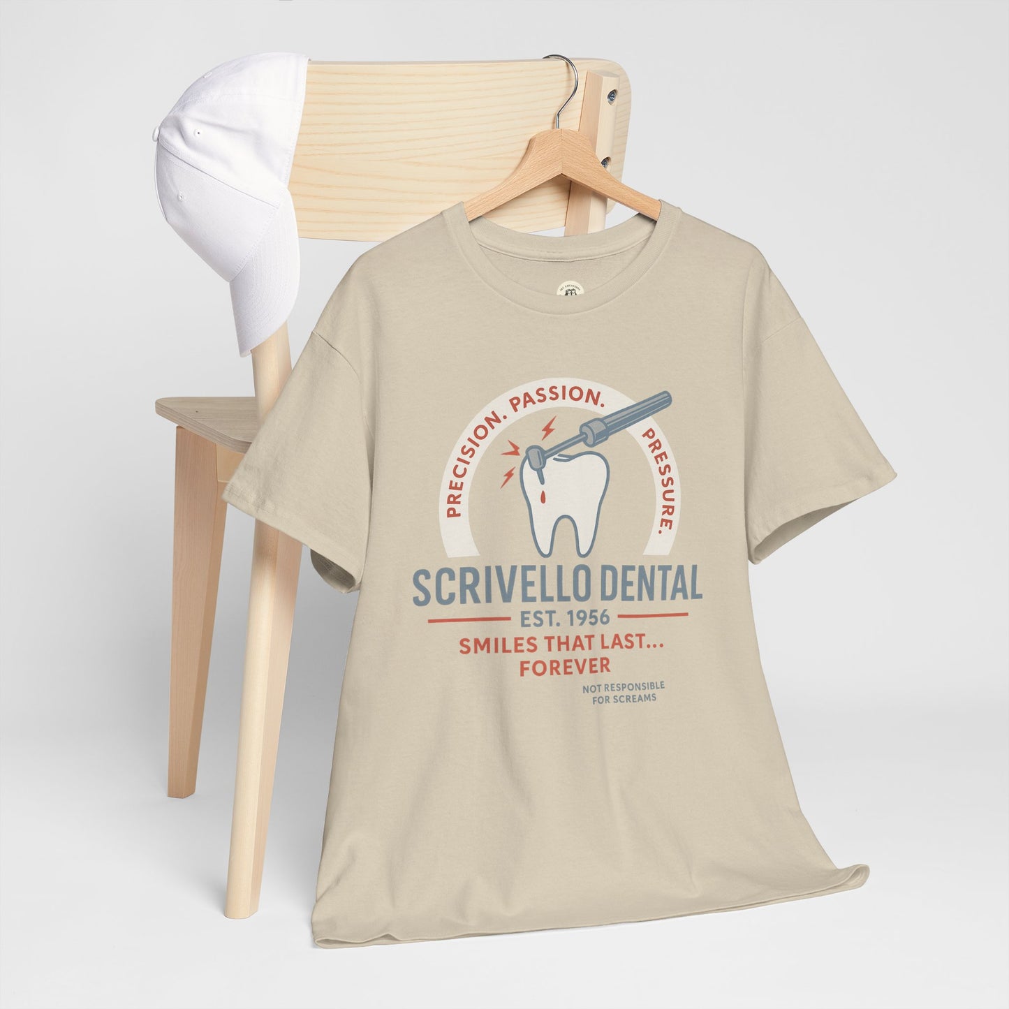 Printify beige Little Shop of Horrors t-shirt with dental graphic and text hanging on wooden chair