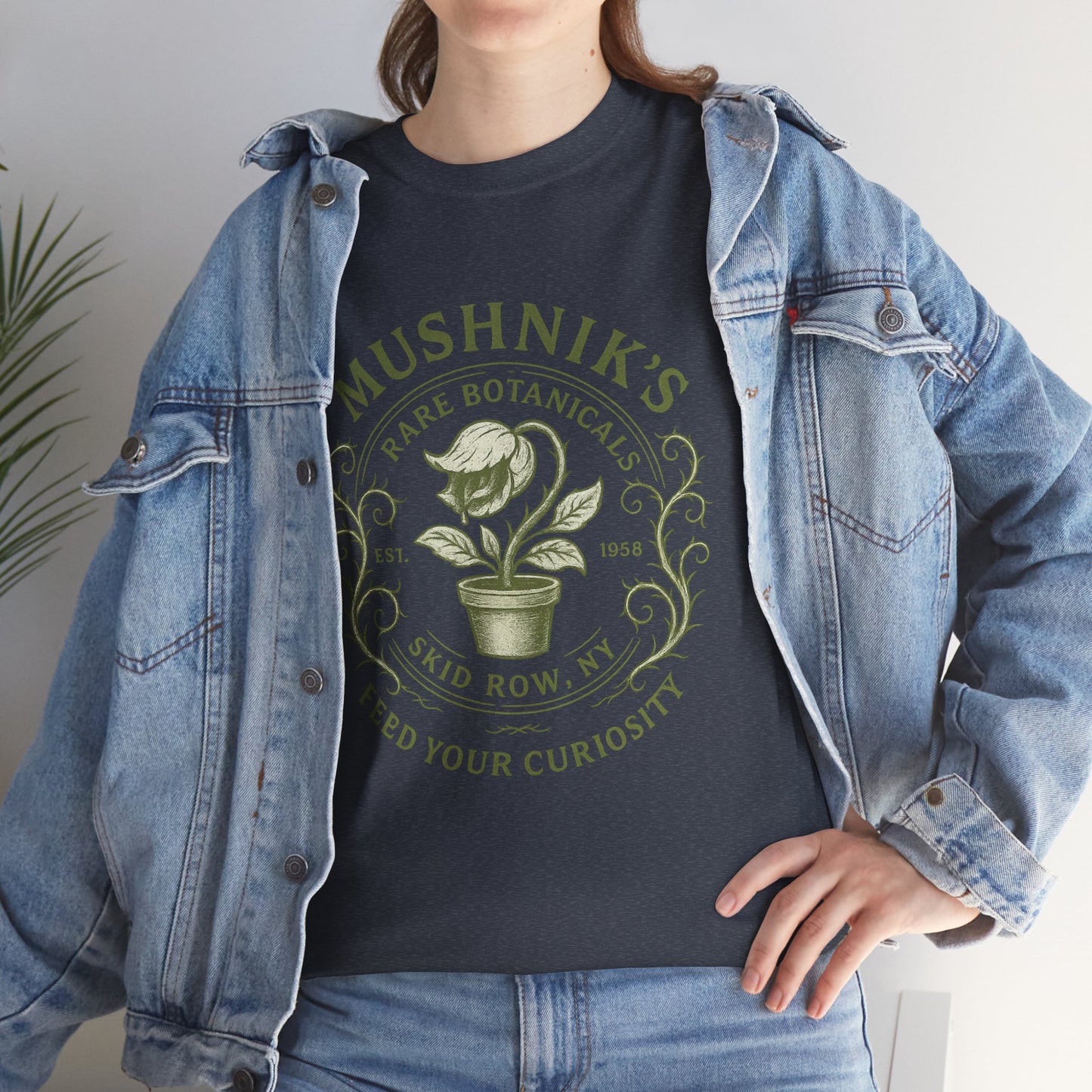 Person wearing Little Shop of Horrors t-shirt with Mushnik's Rare Botanicals design paired with denim jacket