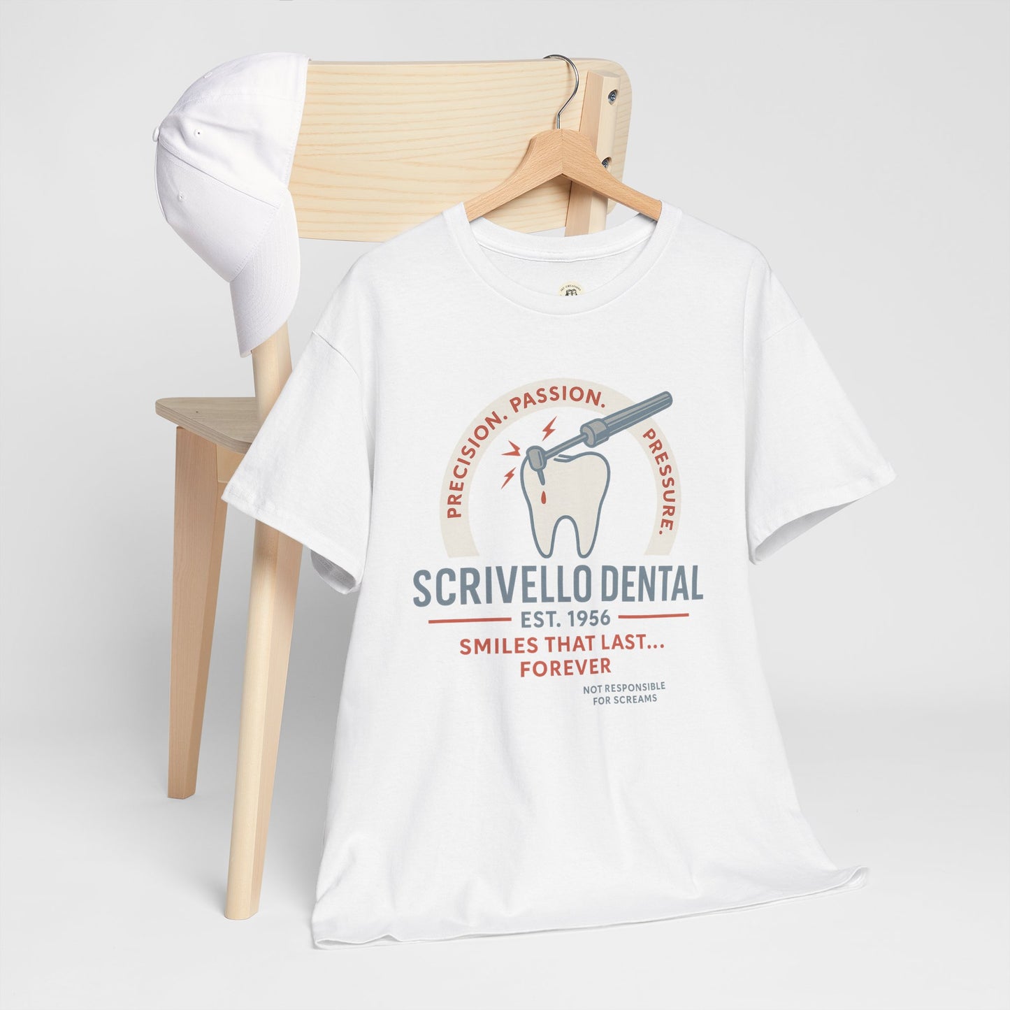 White Little Shop of Horrors t-shirt with Scrivello Dental graphic hanging on wooden chair with white cap