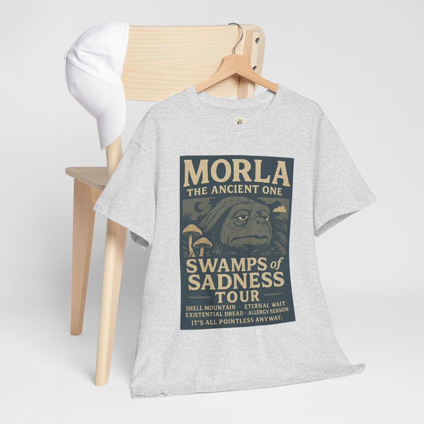Gray Neverending Story Morla t-shirt with vintage swamp-themed graphic design hanging on wooden chair
