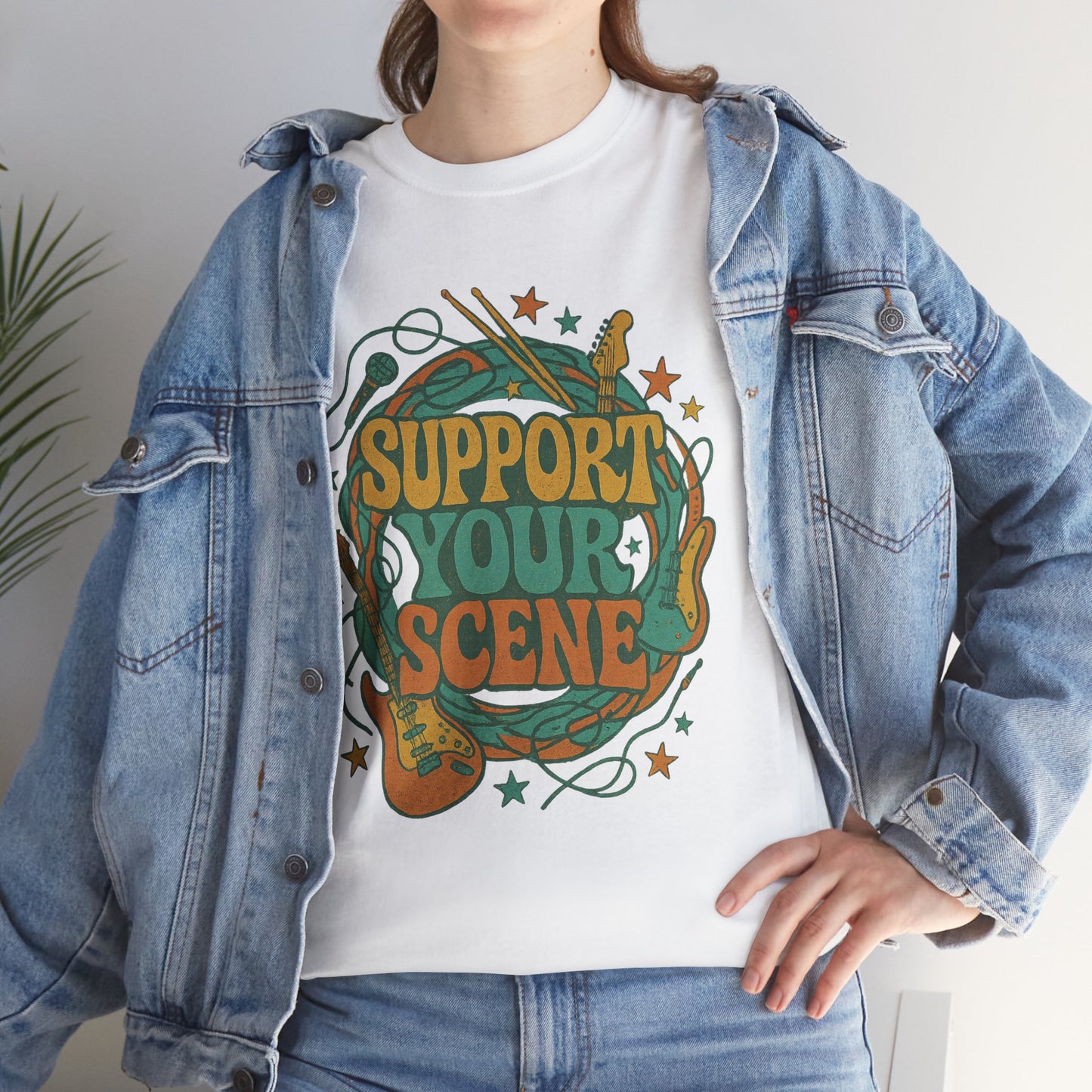White support your scene t-shirt with colorful music-themed graphic worn under denim jacket
