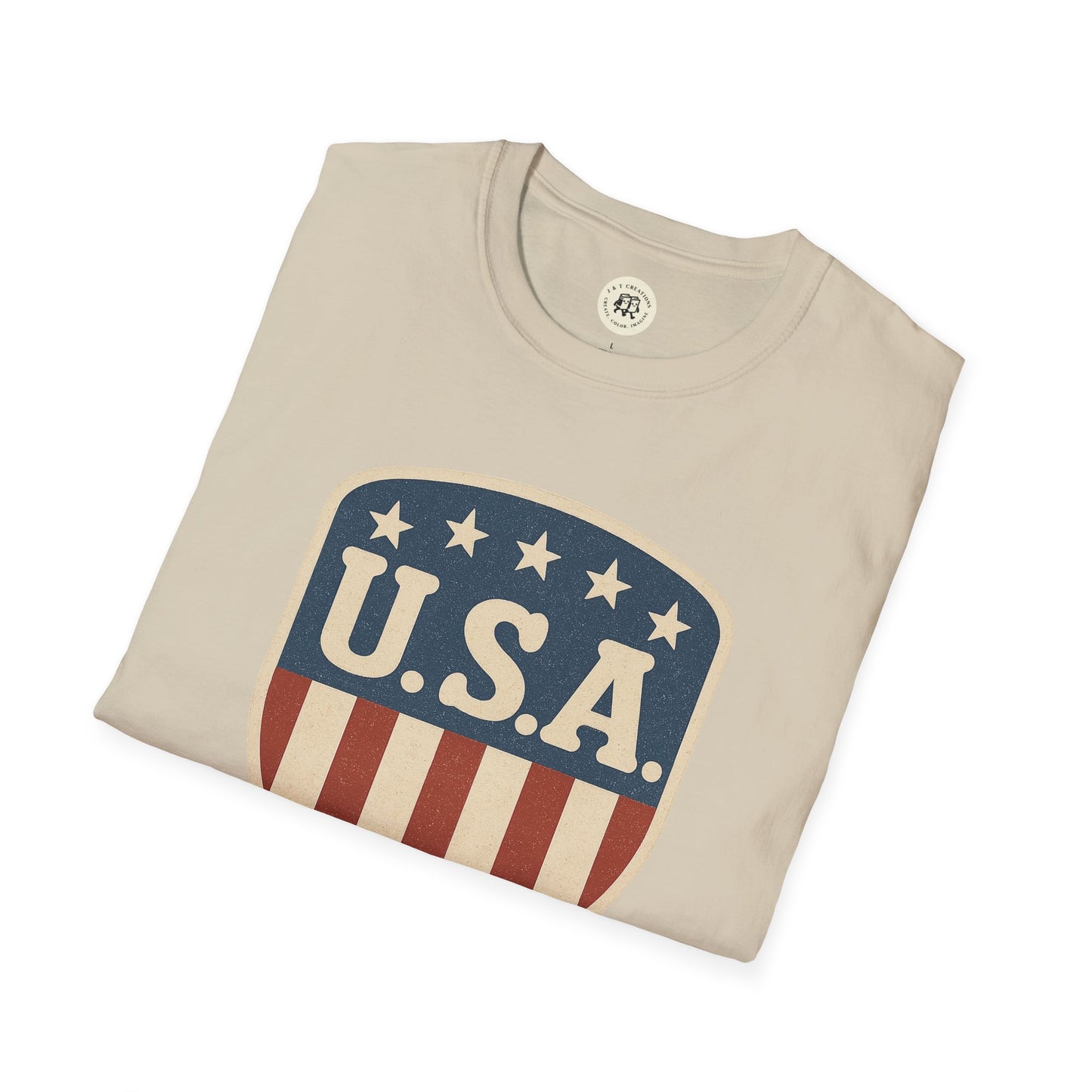 Beige USA shield t-shirt by Printify with patriotic stars and stripes design folded neatly