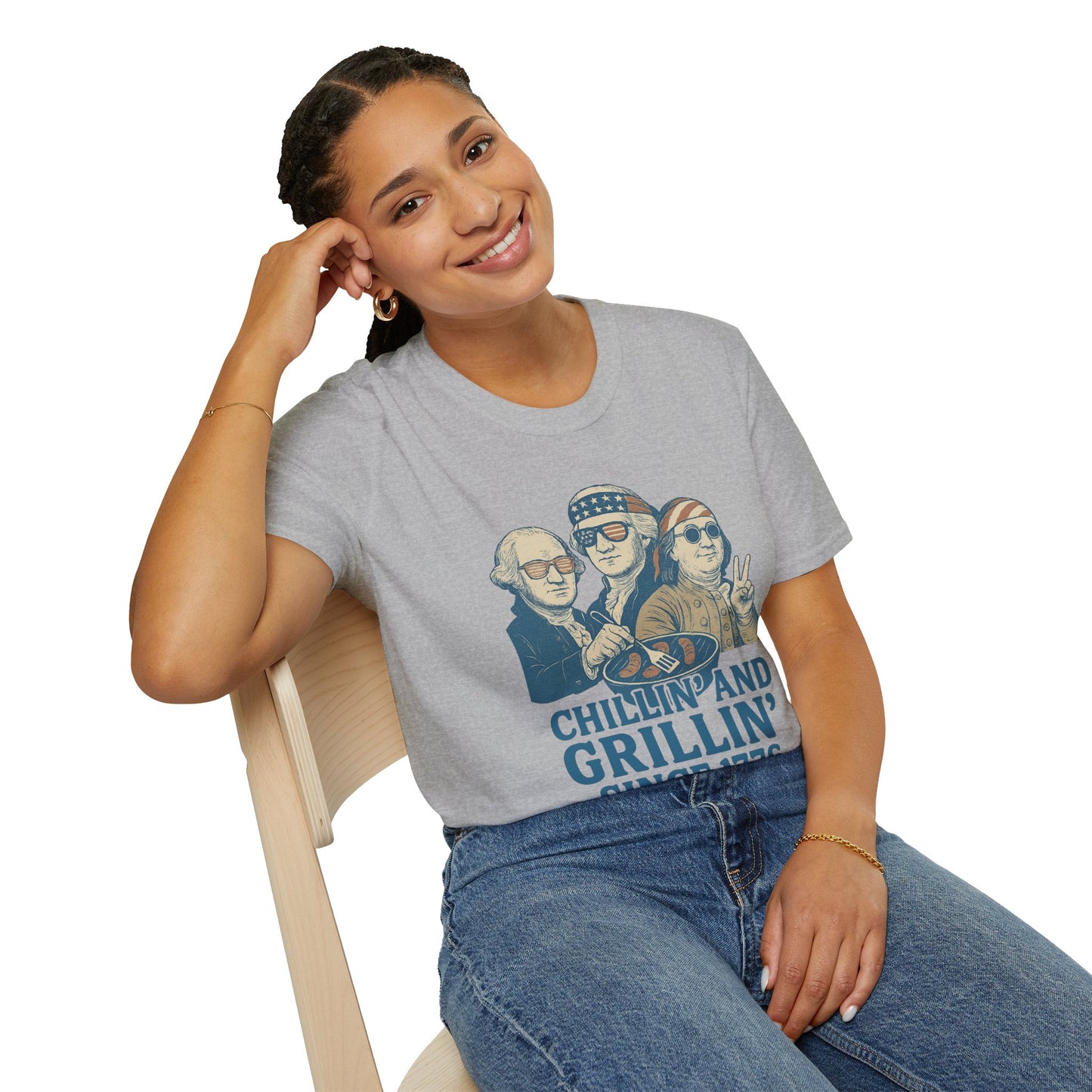 Woman wearing a grey vintage 4th of July t-shirt with patriotic chillin and grillin graphic sitting on chair