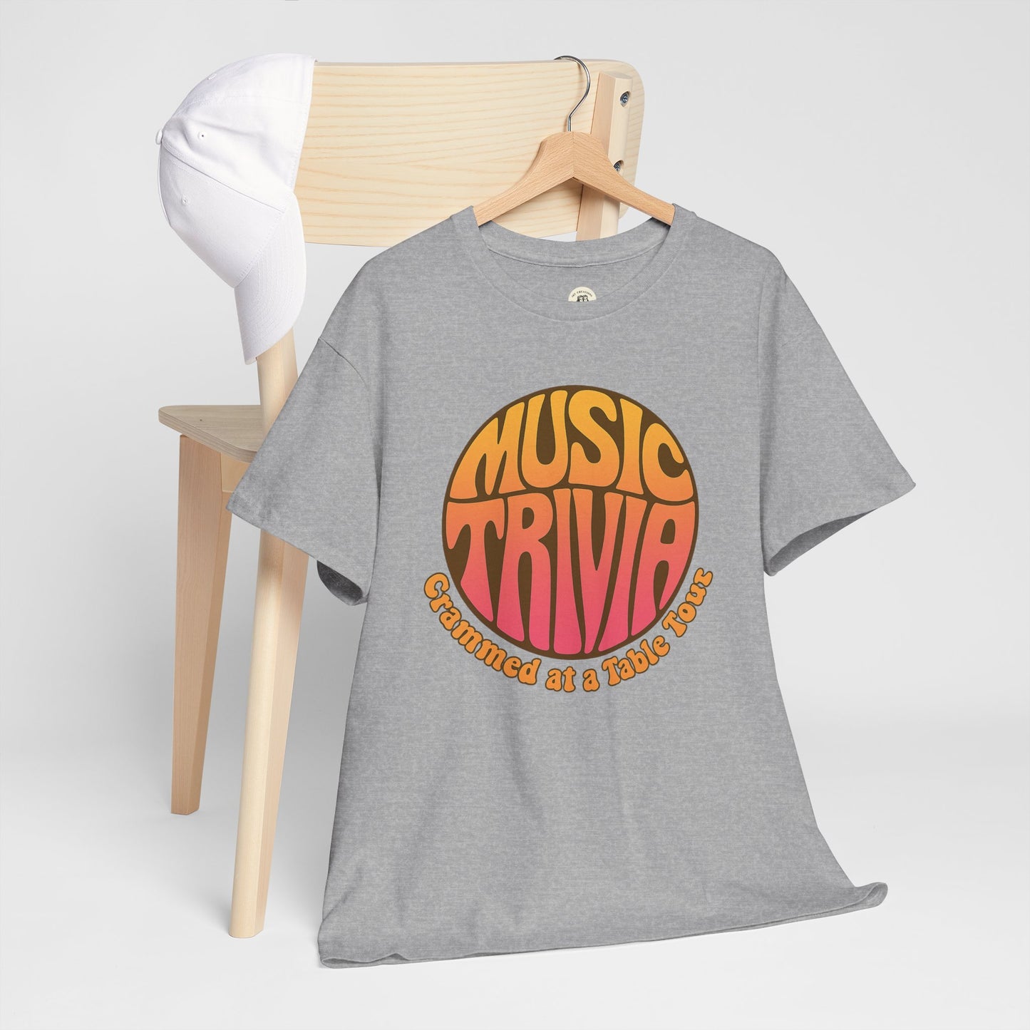 Gray vintage music trivia t-shirt with colorful retro design hanging on wooden chair with white cap