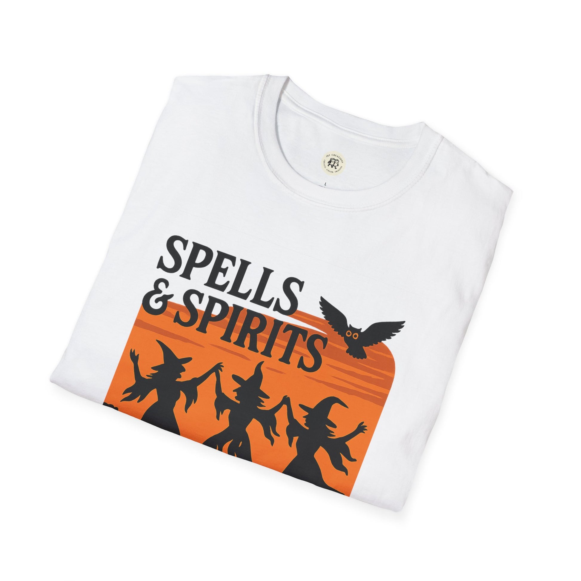 Folded white spooky vibes unisex halloween t-shirt with orange Spells and Spirits graphic of dancing witches and owl