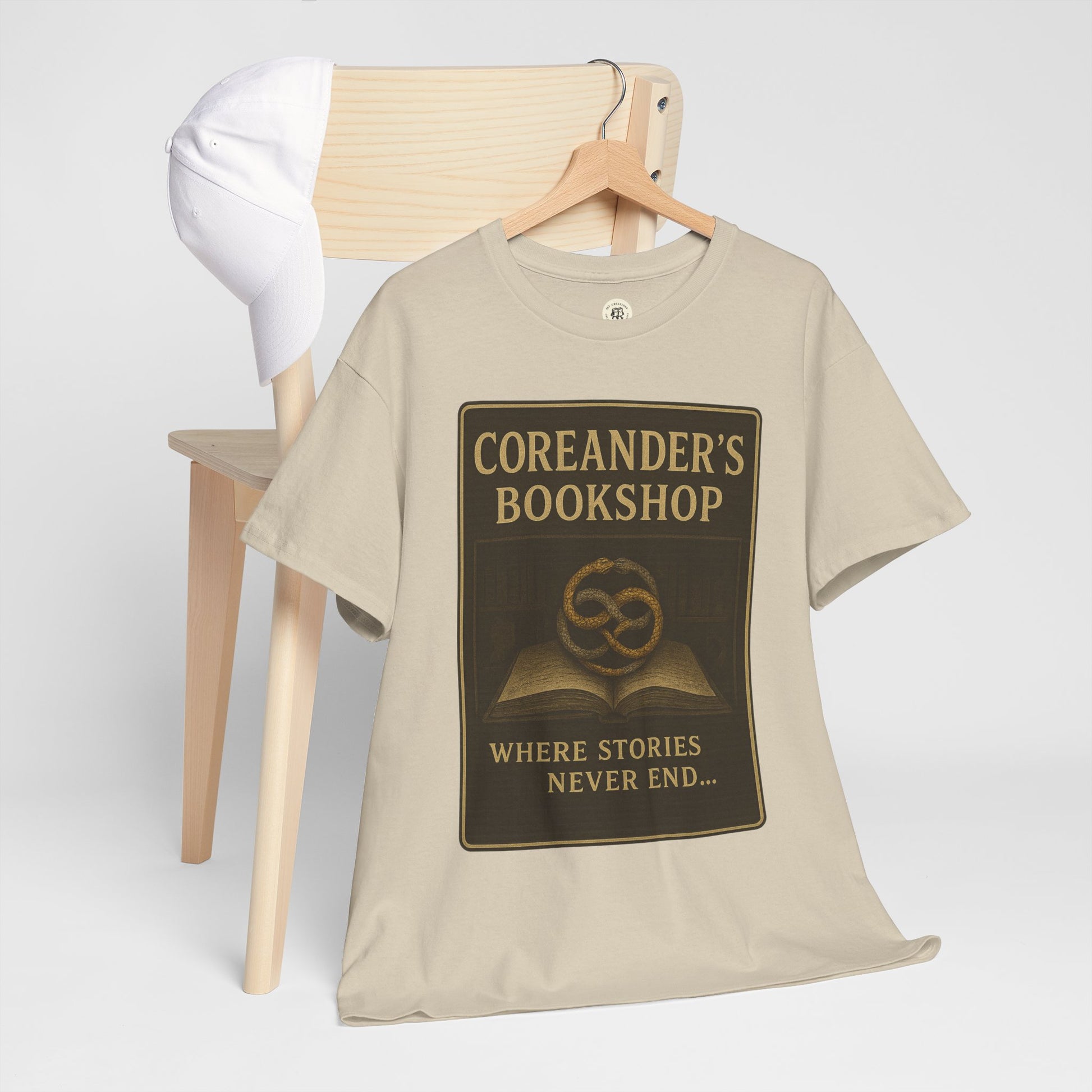 Printify beige Neverending Story t-shirt with Coreander's Bookshop graphic and text design